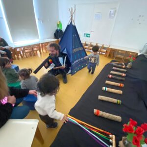 sala con niños y niñas mas el artista educador tocando instrumentos