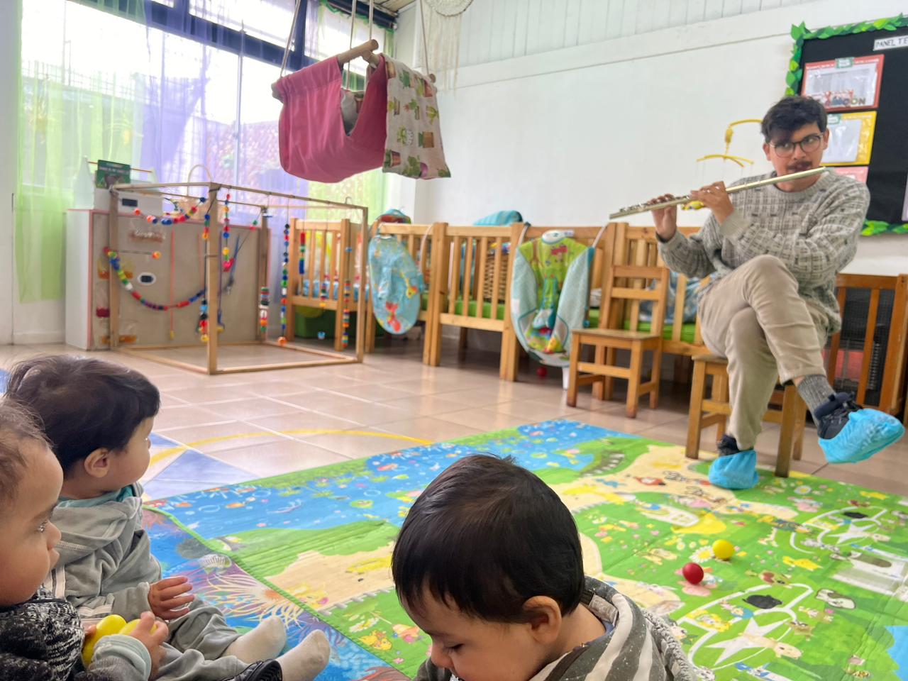 niños y niñas escuchando a un músico