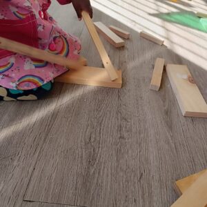 niña golpeando el suelo con unas tablas
