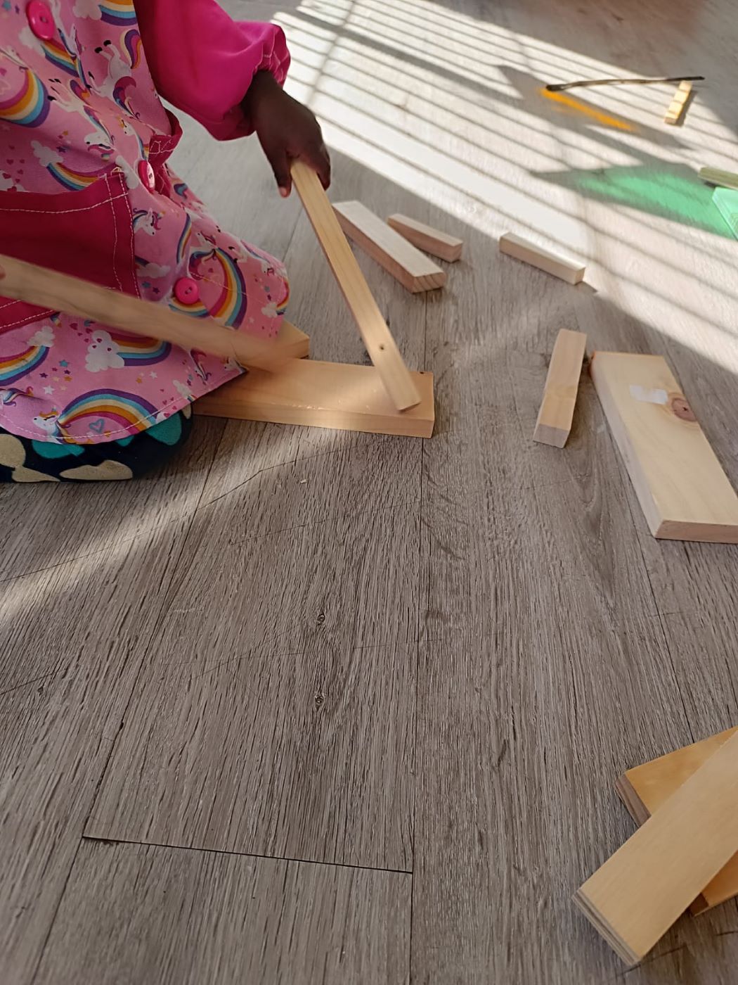 niña golpeando el suelo con unas tablas