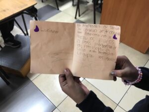manos de niños sosteniendo una carta