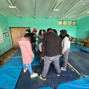 Grupo de jóvenes en círculo sobre colchonetas