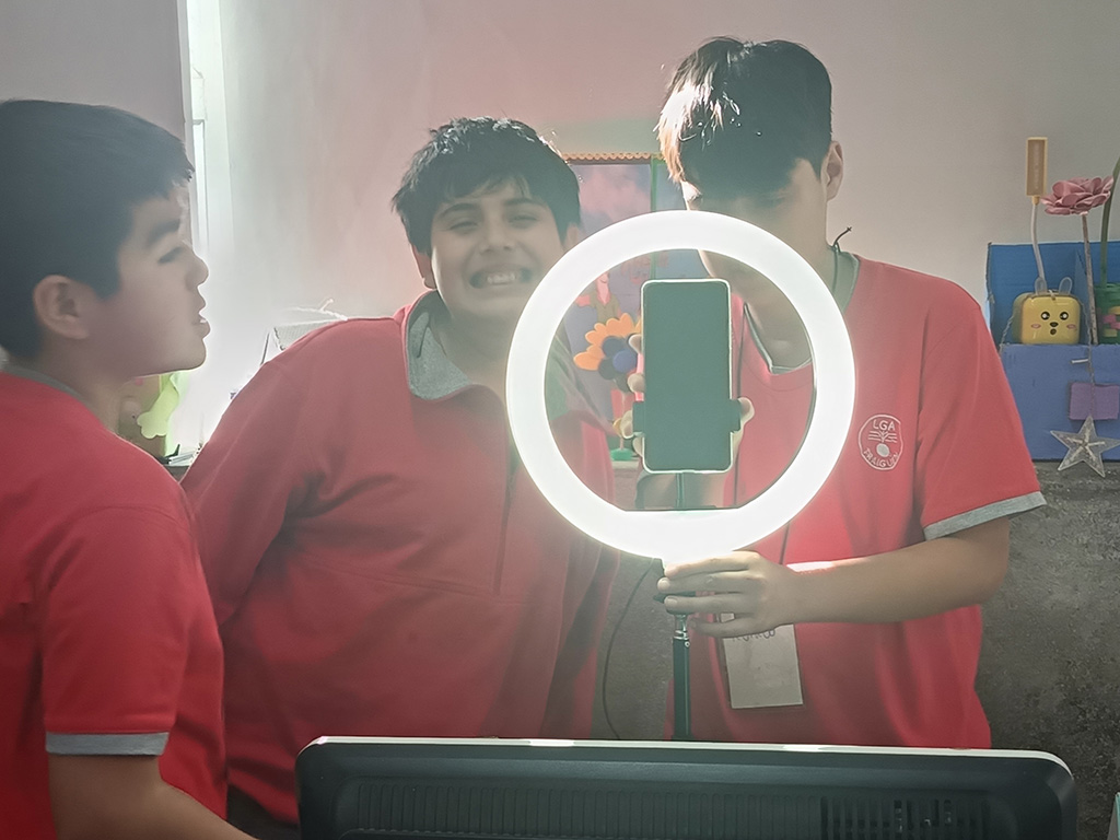 Niños sandose una foto con un aro de luz que sostiene un celular