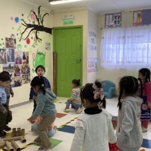 Niños jugando en sala de clases. Se encuentran haciendo actividades con conos de papel higiénico, papel celofán y papel de diario.