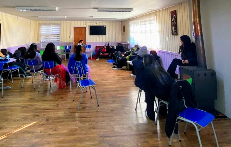 Jovenes sentados en sillas azules conversando