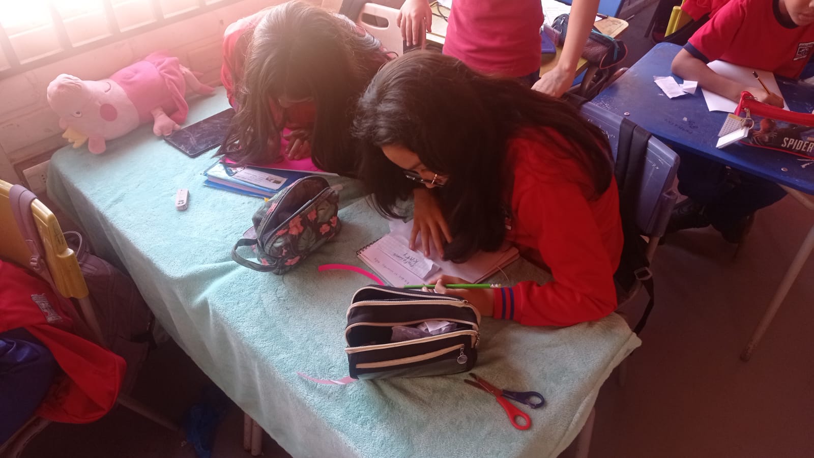 Niñas mirando unos apuntes en sus cuadernos