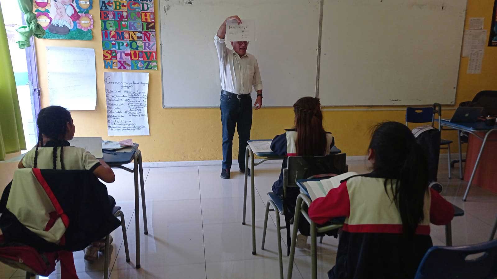 Educador presentado una hoja escrita a sus alumnos