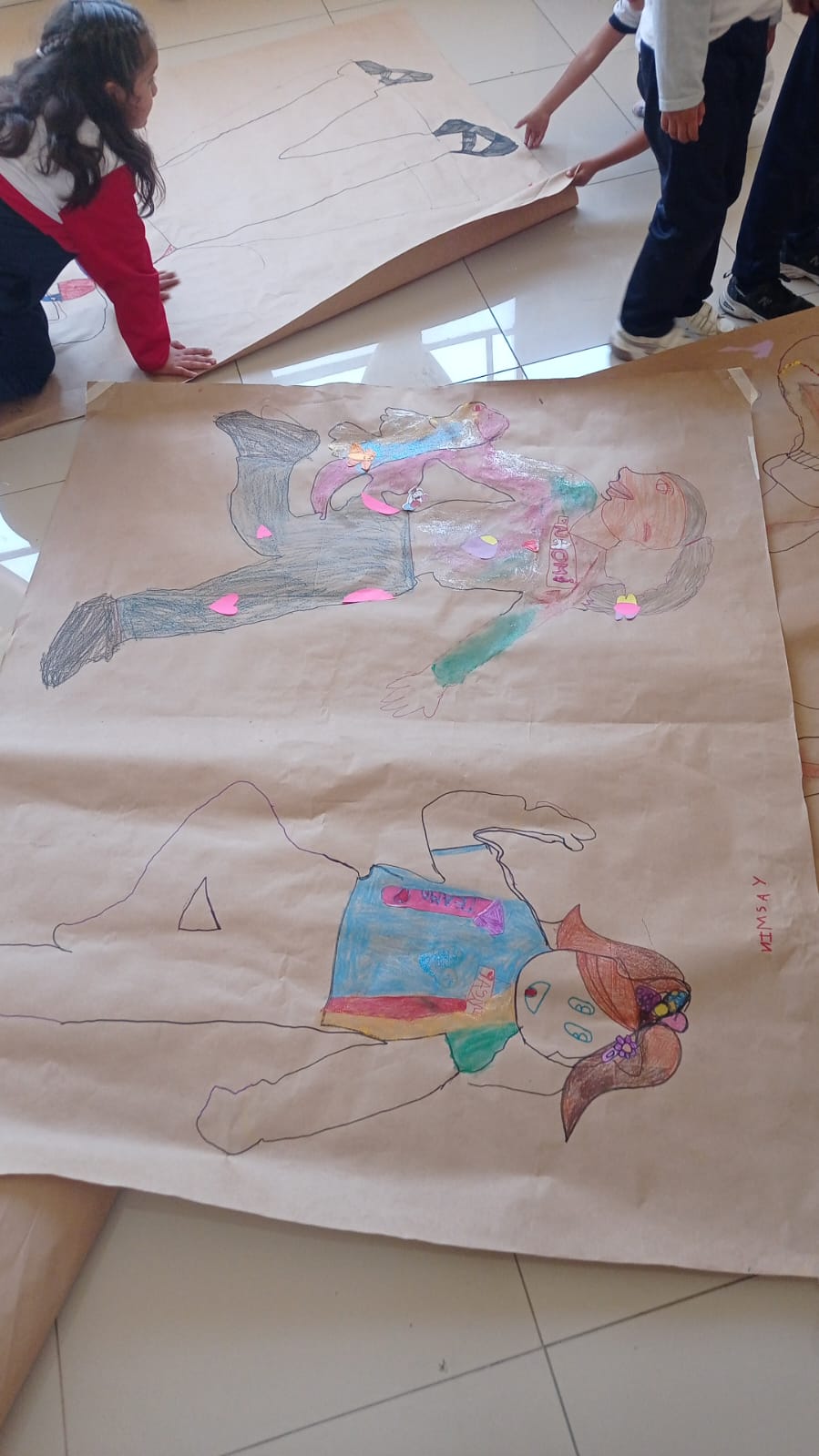 niñas haciendo dibujos sobre pliegos
