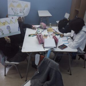 niñas pintando sobre un hoja de papel durante la clase