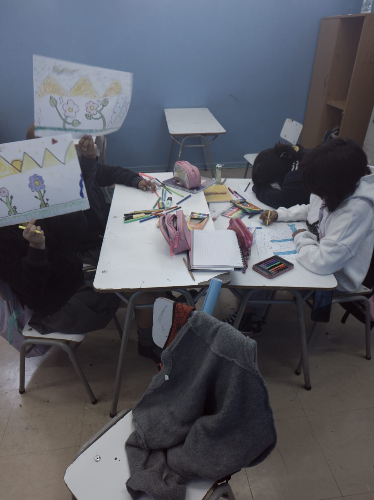 niñas pintando sobre un hoja de papel durante la clase