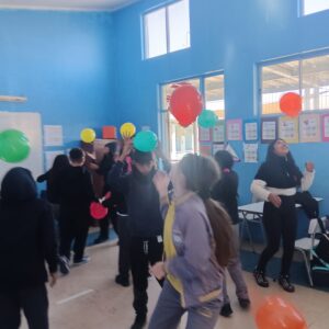 niños y niñas jugando con globos