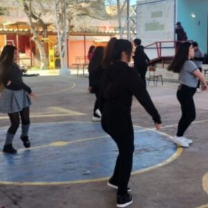 niños y niñas bailando en una cancha