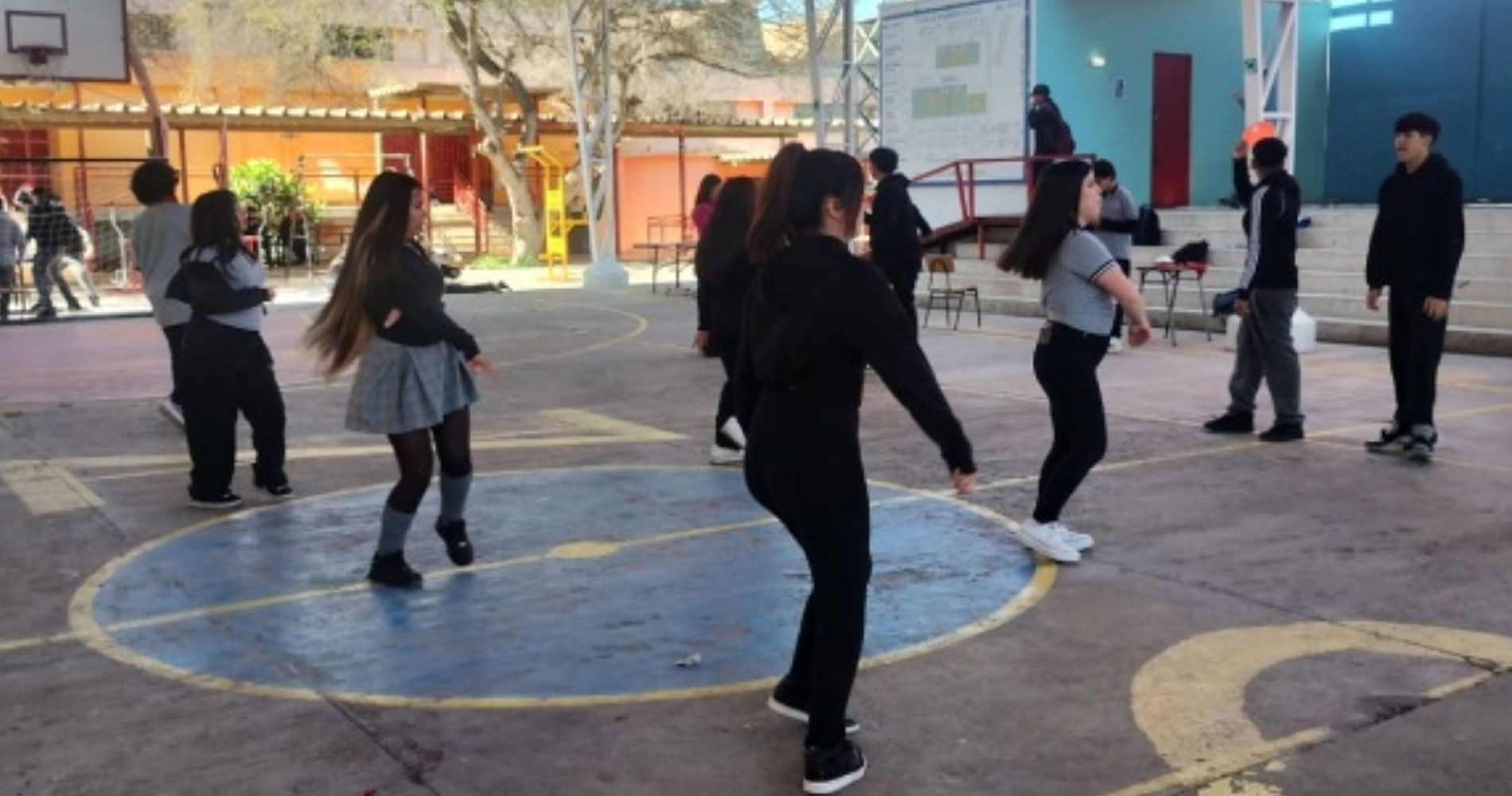 niños y niñas bailando en una cancha