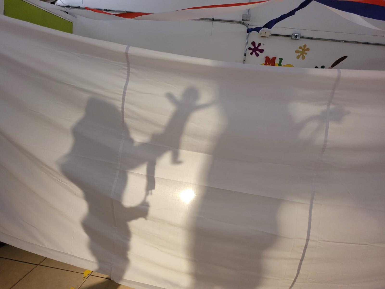 Sombras de 2 niños sobre sábana blanca