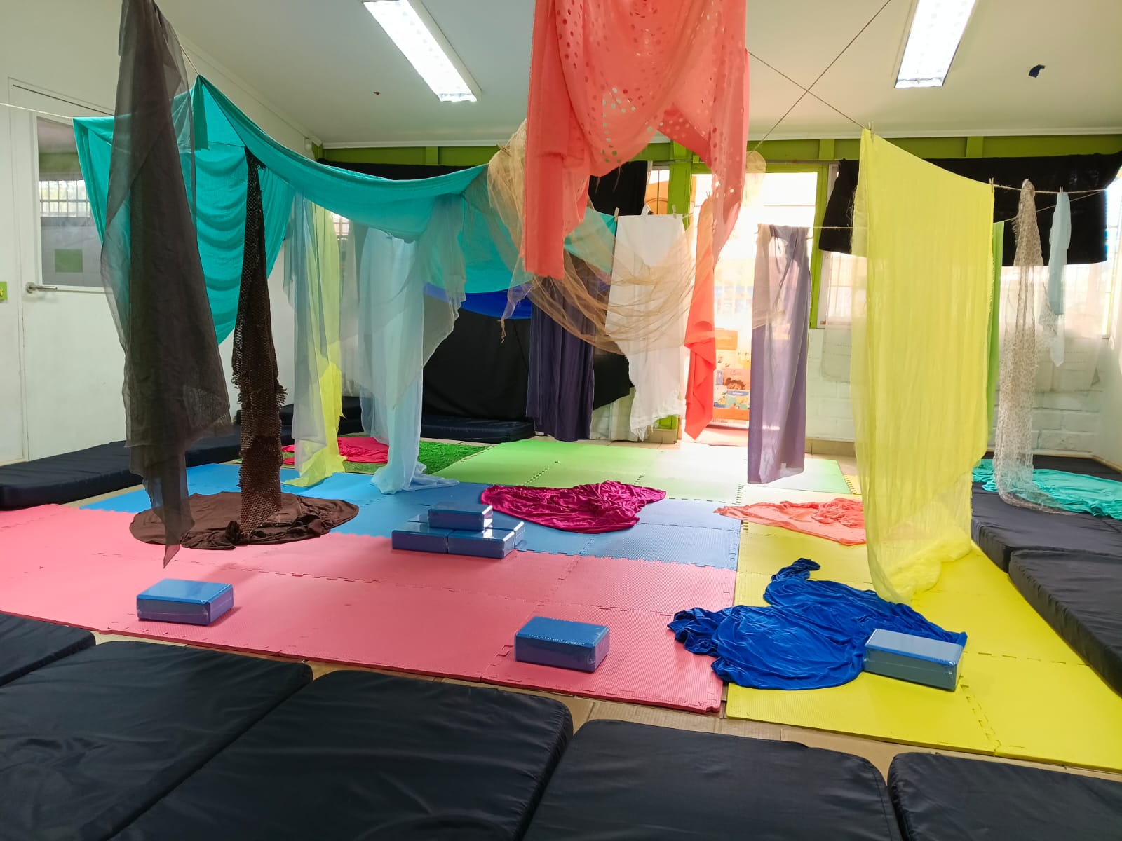 Sala de clases con colchonetas y velos