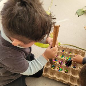 Niños jugando con caja de huevos y dulces de colores