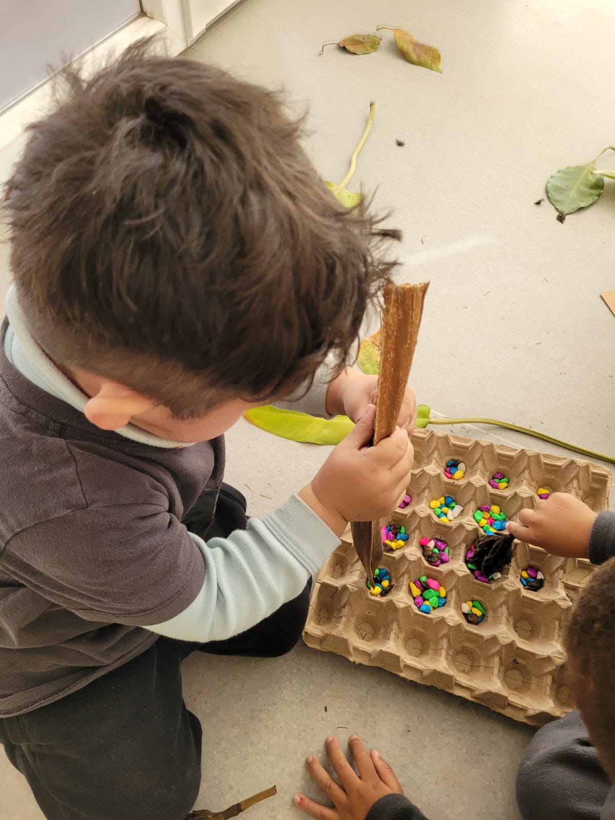 Niños jugando con caja de huevos y dulces de colores