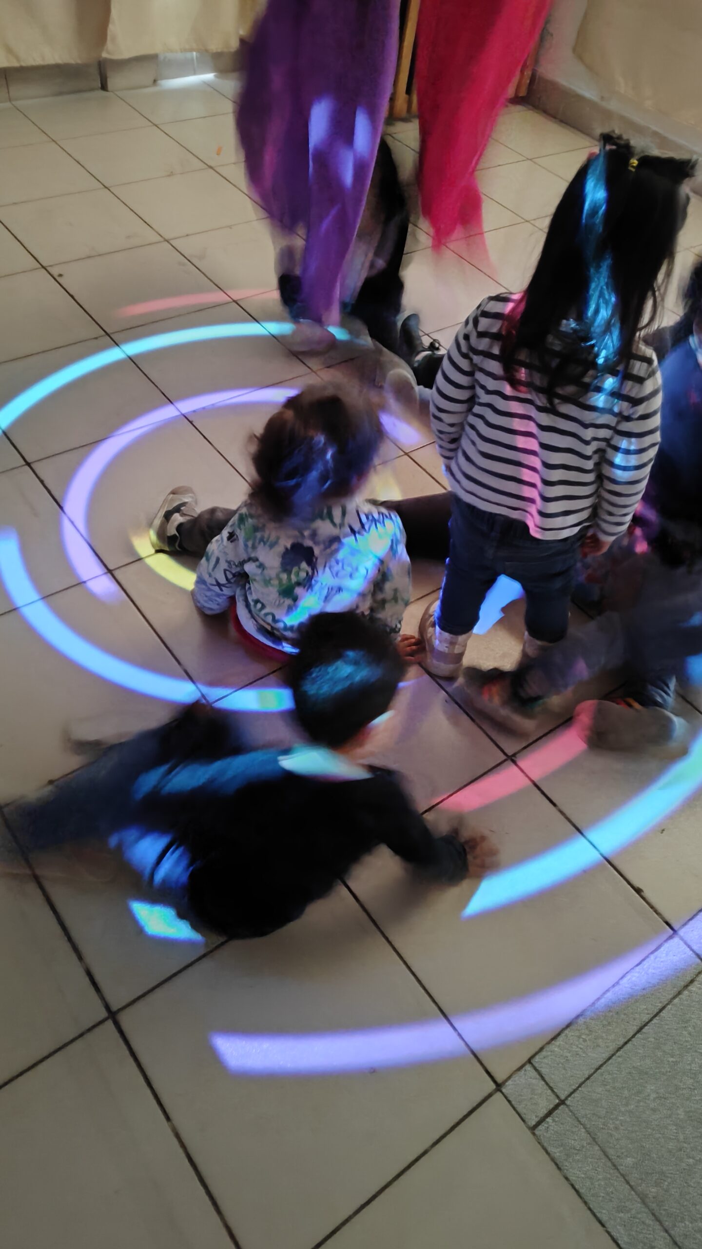 Niños entre velos de colores y luces