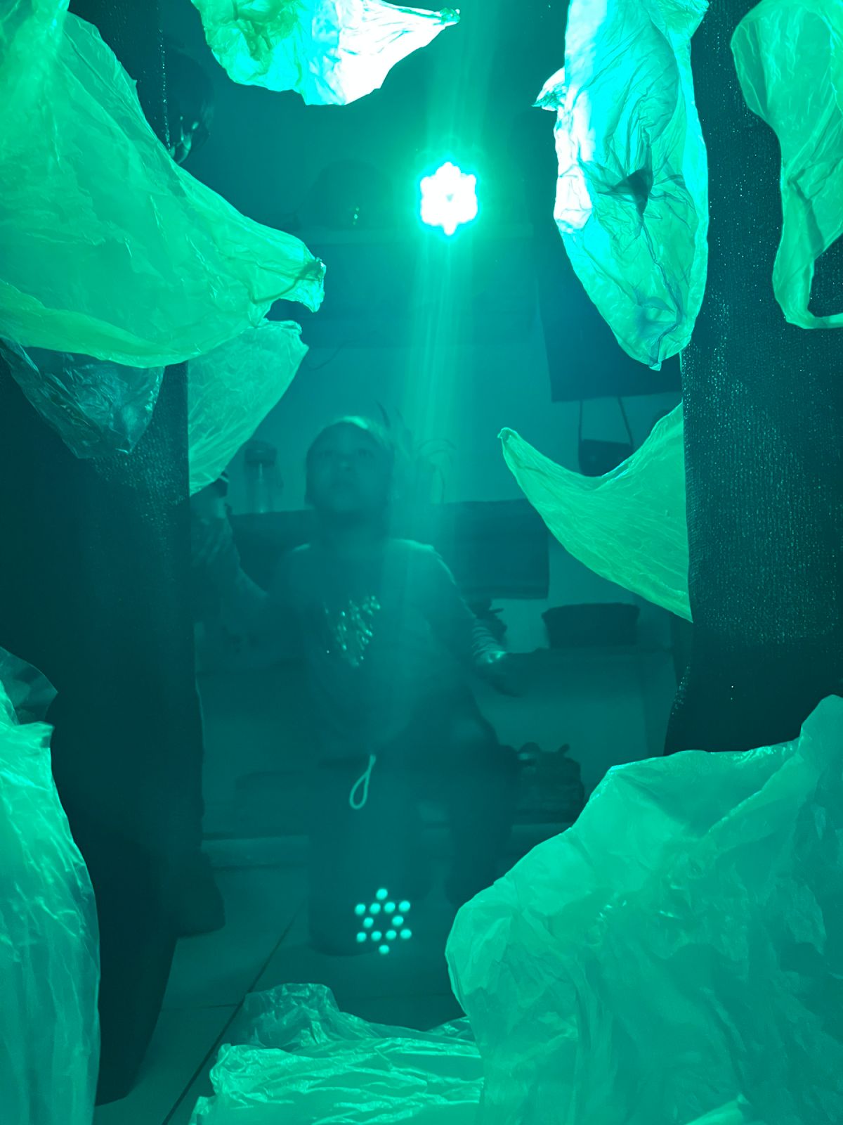 Niño rodeado de velos con luz verde