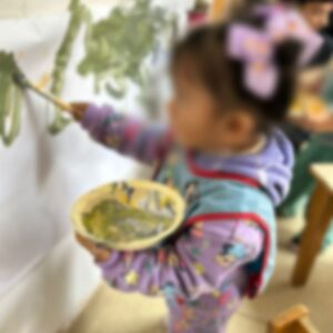 Niña pequeña pintando en la pared