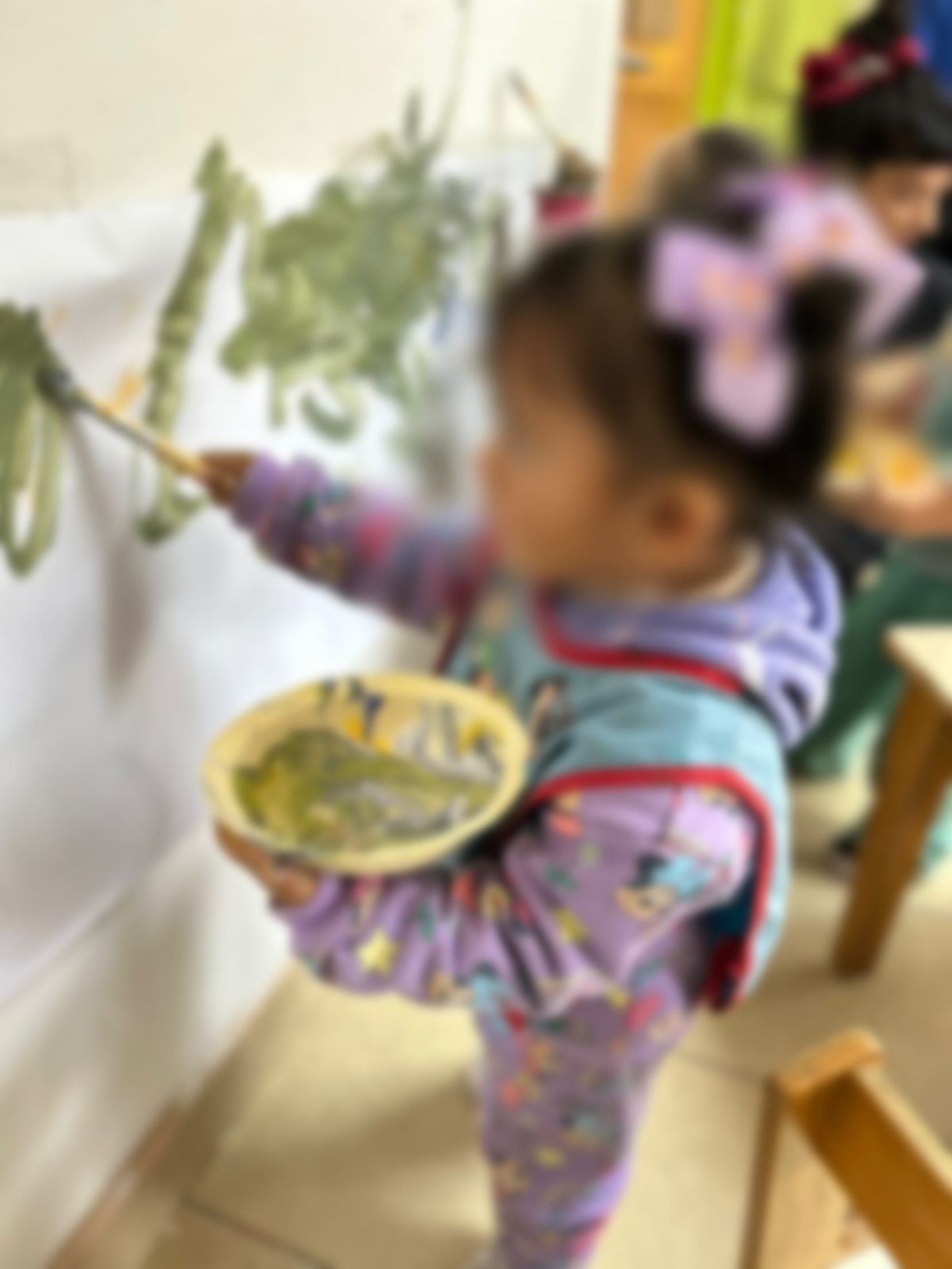 Niña pequeña pintando en la pared