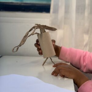 manos de niña jugando con un tubo de carton