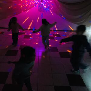 Niños en la oscuridad jugando con luces de fondo