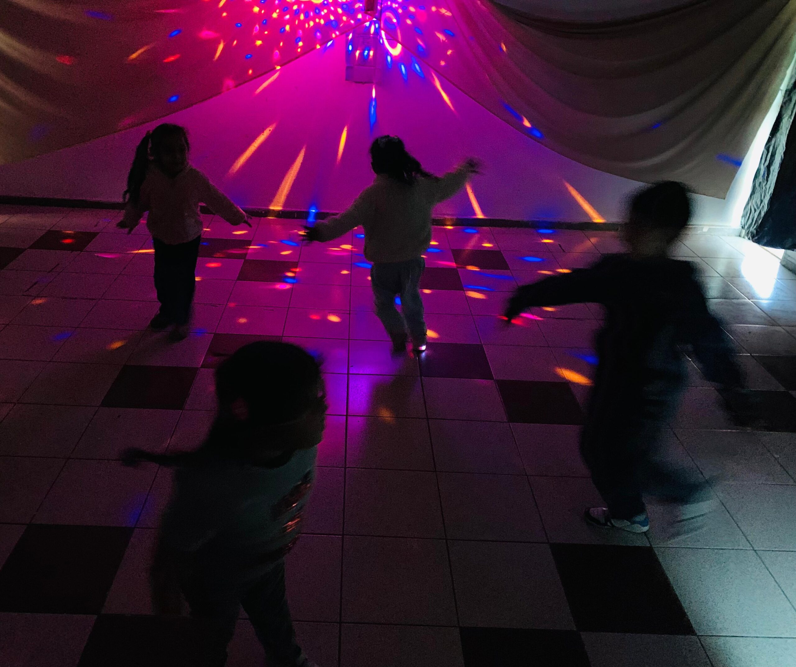 Niños en la oscuridad jugando con luces de fondo