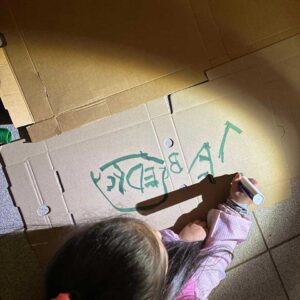 niña dibujando con un plumon sobre carton