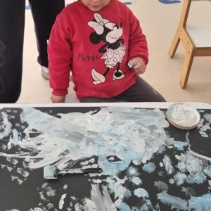 niña pintando con sus manos sobre un papel