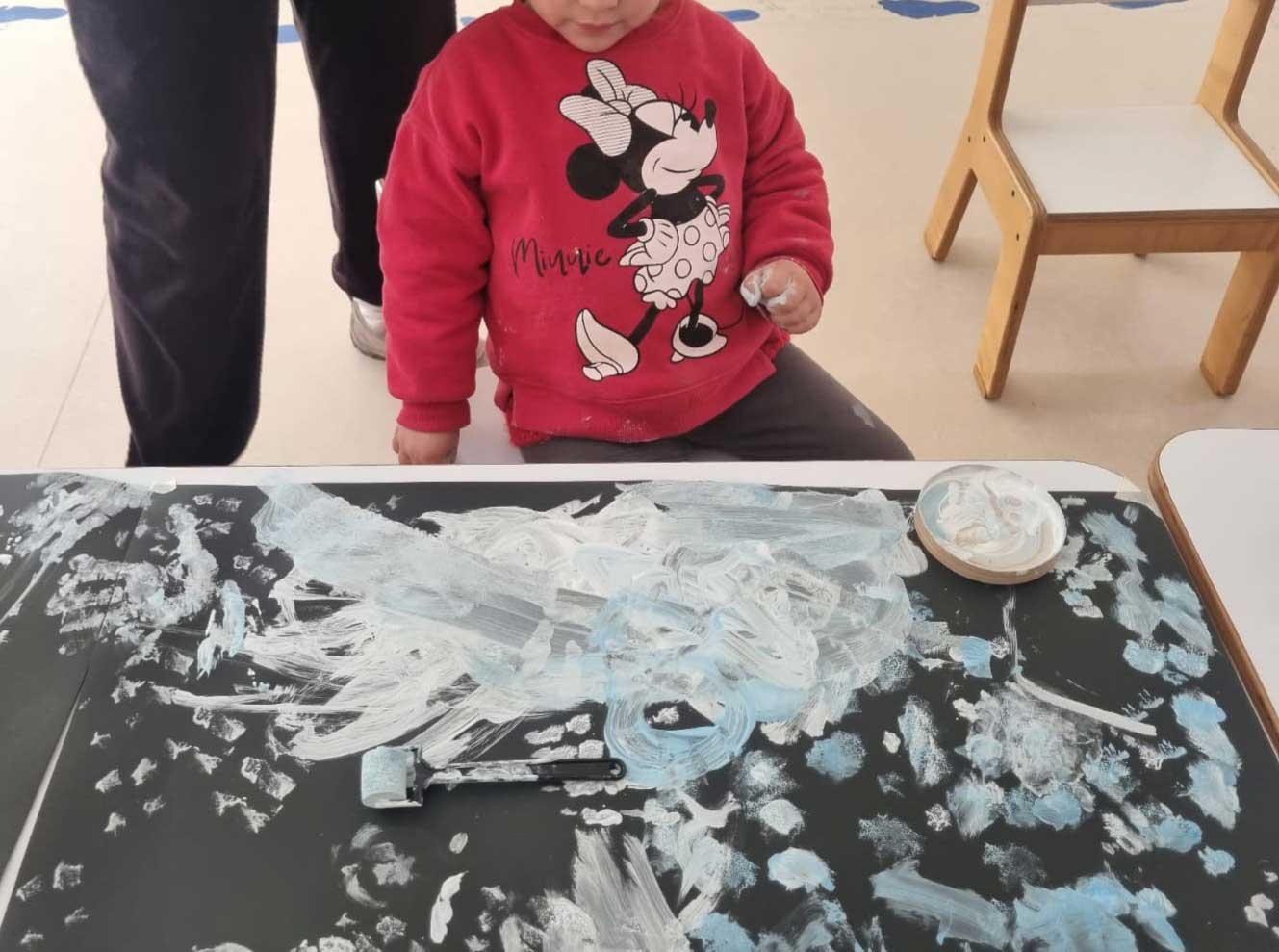 niña pintando con sus manos sobre un papel