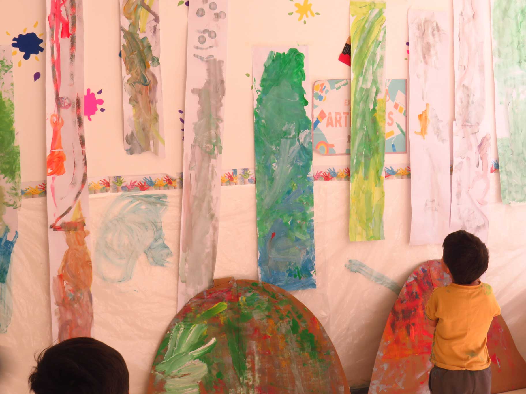 Niño observando pinturas sobre papel