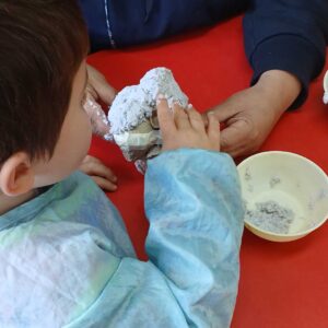 Niño trabajando con una masa de papel molido