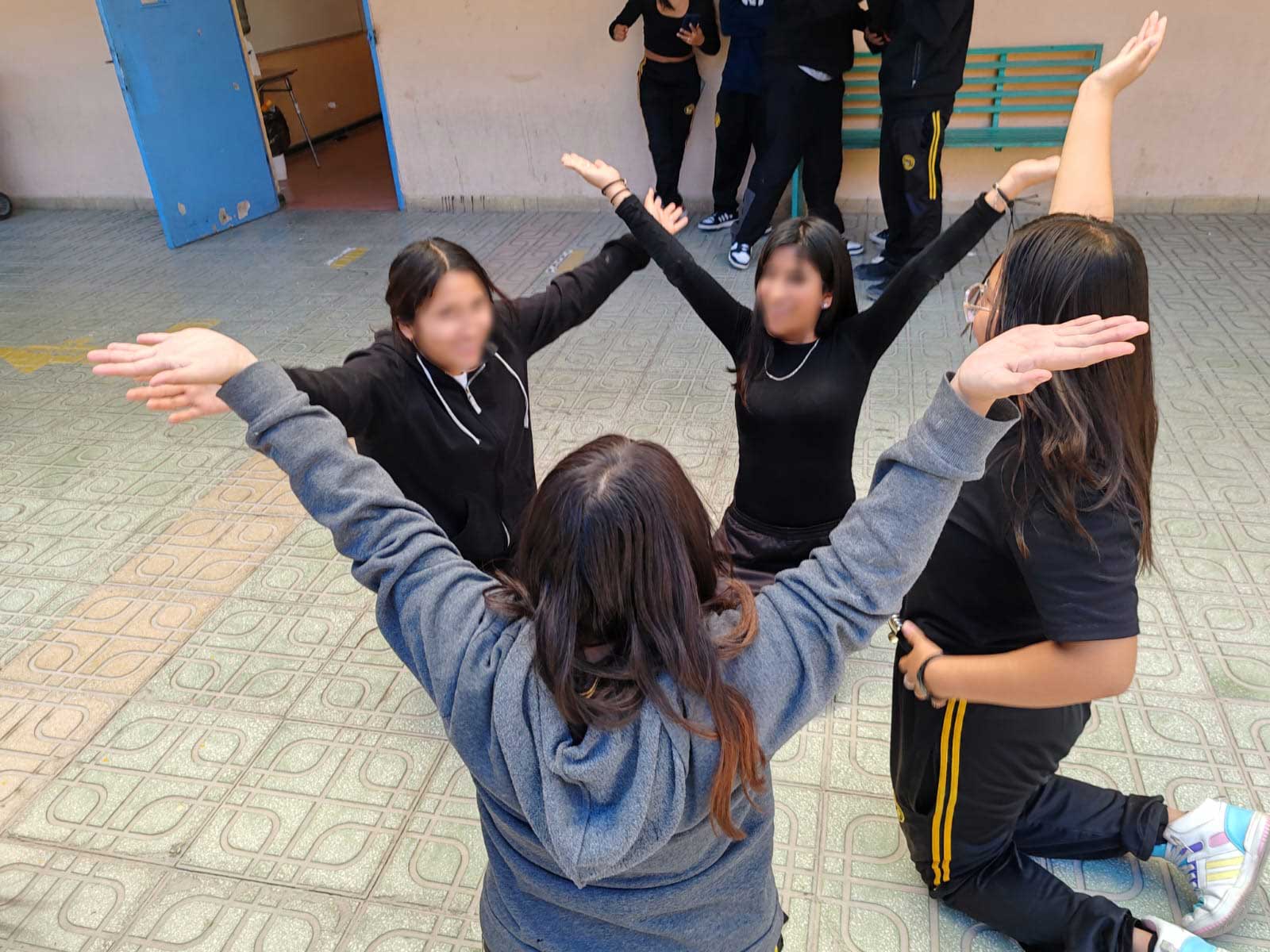 niñas haciendo una coreografia con los brazos en alto