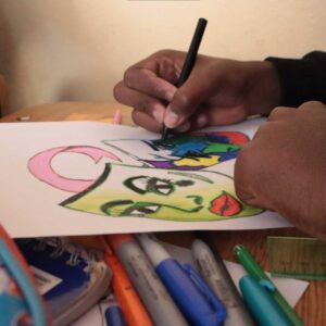 manos pintando unos dibujos de mascaras