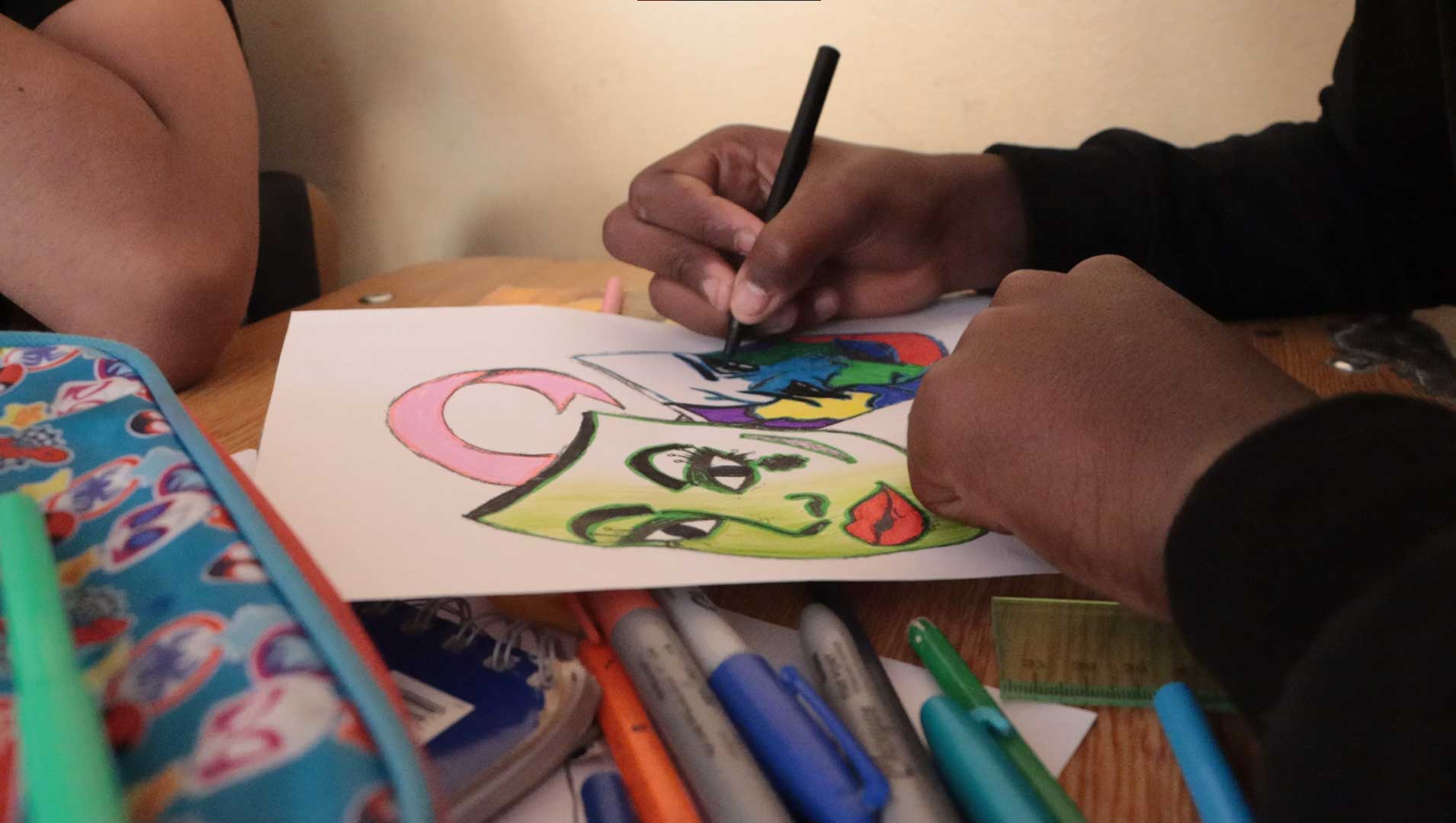 manos pintando unos dibujos de mascaras