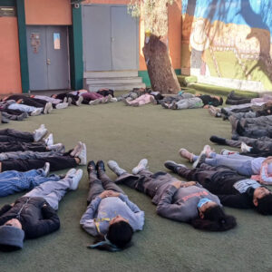 niños y niñas acostados en el suelo en un circulo