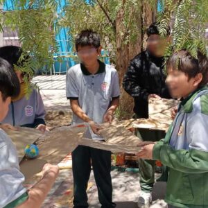 seis niños jugando con unos cartones en el patio