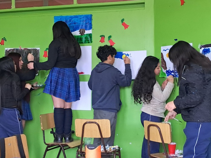 niños y niñas escribiendo sobre unos papeles en la pared
