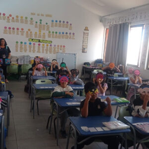 niños y niñas dentro de una sala de clases con sus mascaras puestas