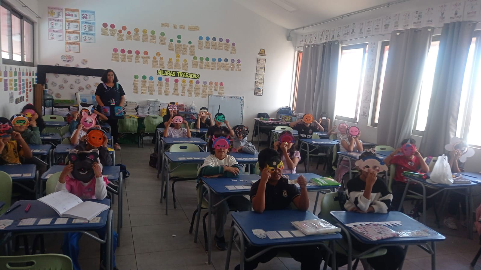 niños y niñas dentro de una sala de clases con sus mascaras puestas